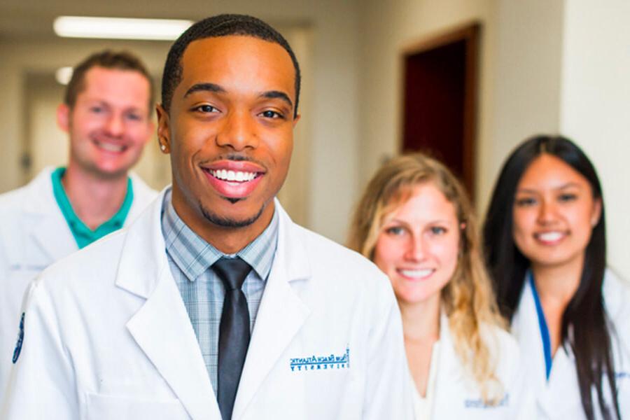 students from the doctor of pharmacy program standing in a hallway smiling